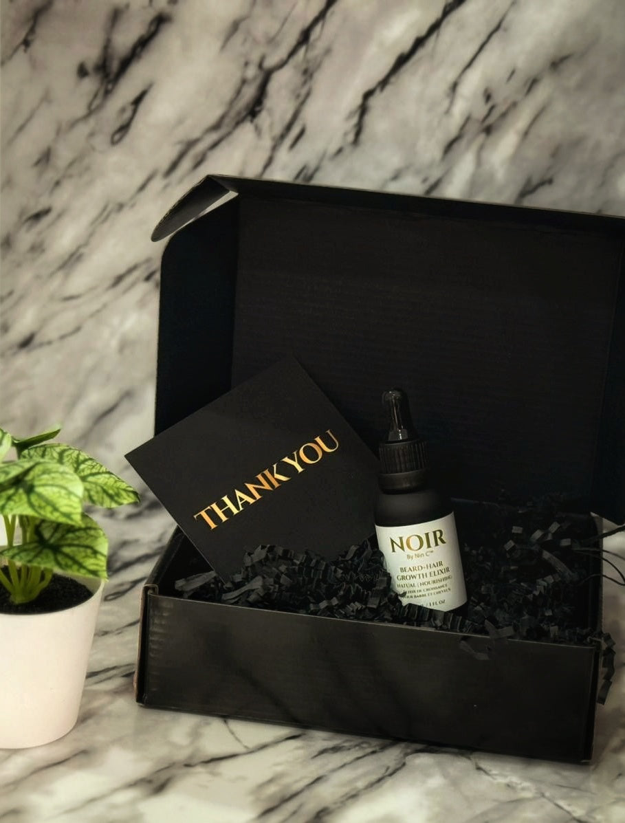 NoirByNinC Beard Elixir unboxing in luxury black gift box with thank you card on marble background